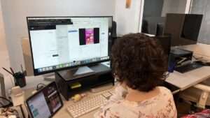 Miembro del equipo de Yumagic trabajando en la oficina de Barcelona frente a un monitor de edición